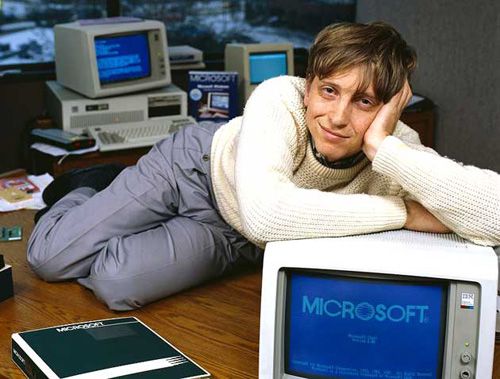 1985, Bellevue, Washington, USA --- Bill Gates, CEO of Microsoft, reclines on his desk in his office soon after the release of Windows 1.0. --- Image by   Deborah Feingold/CORBIS 1 Adults Americans Bellevue Bill Gates Business and commerce Businesspeople CEO Clothing Company executive Computer Computer hardware Cream Desk Eye contact Full-length portraits Full-length studio portraits Furniture Gray Hands on head Indoors King County Males Men Microsoft Corporation North America Office Pacific Northwest Pants People Personal computer Portraits Prominent persons Reclining Room Software manufacturer Studio portraits Sweater USA Washington State White Whites Window