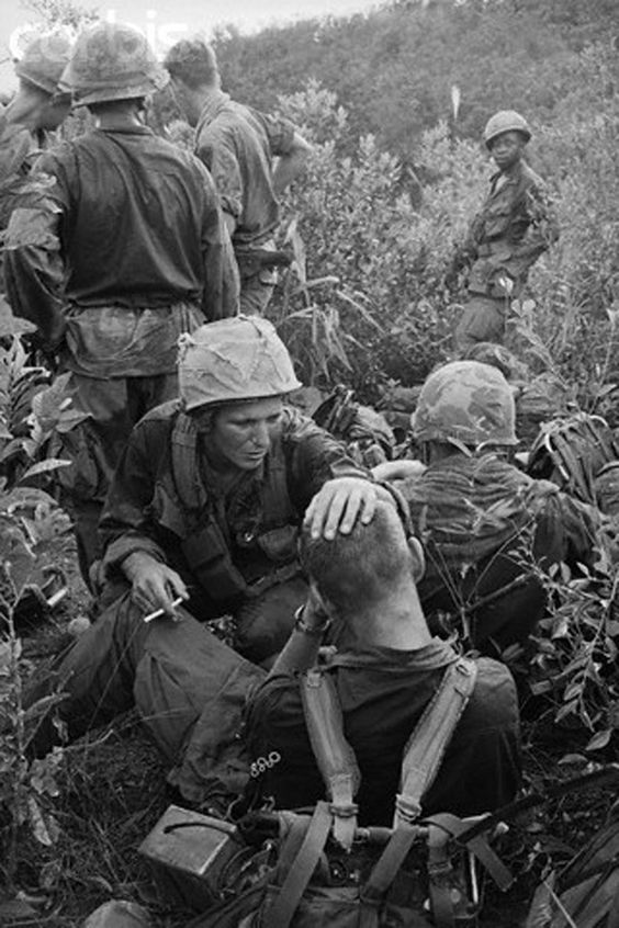 08 Nov 1967, Near Tam Ky, South Vietnam --- A stressed 1st Cavalry soldier is cheered by his buddy moments after an intense firefight on a search and destroy mission 15 miles northwest of Tam Ky. --- Image by © Bettmann/CORBIS