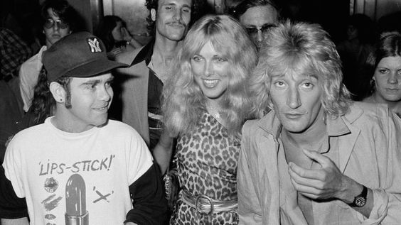 British pop singer Elton John, left, Lana Hamilton, wife of actor George Hamilton, and rock singer Rod Stewart arrive at New York's Studio 54, July 10, 1978, to celebrate at a party given by RCA Records, who signed John to a contract with the recording company.  Others are unidentified.  (AP Photo/G. Paul Burnett)